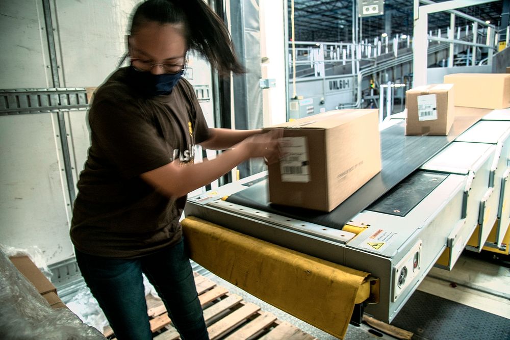 UPS employee Jocelin Zuniga unloads food boxes at the more than 1 million-square-foot UPS Lone Star distribution center…