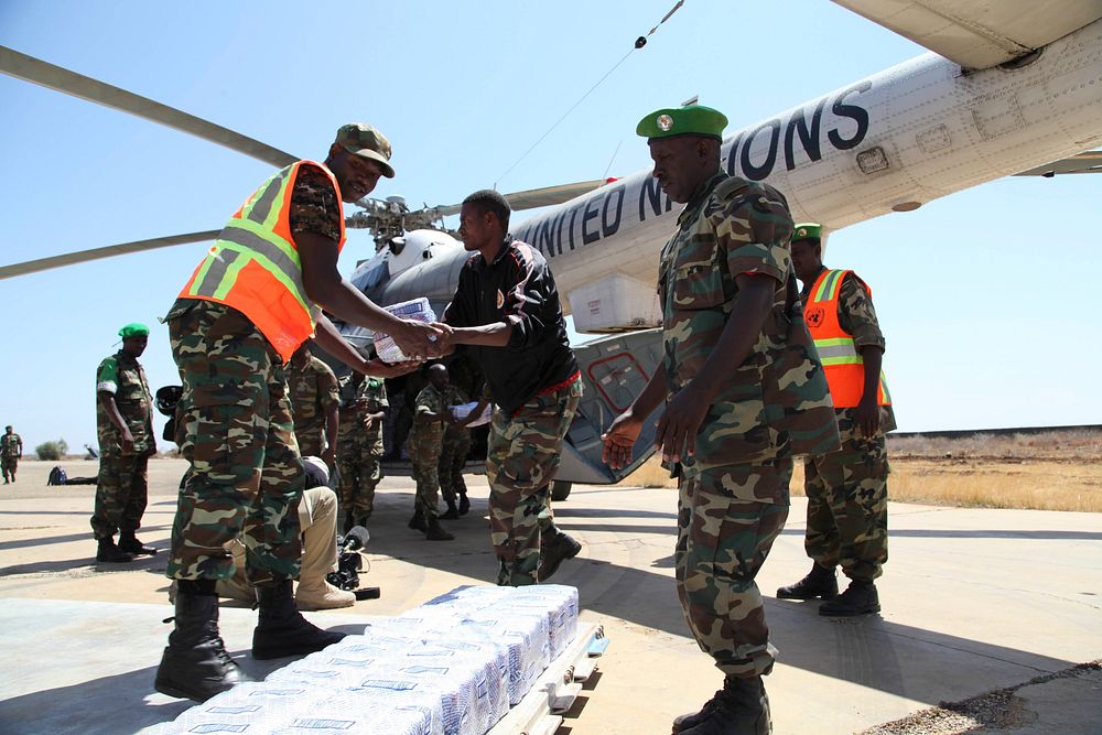 Foodstuffs are offloaded from a UN helicopter at Baidoa Airport on 8 March 2014. AU-UN IST Photo / Mohamed Guled. Original…