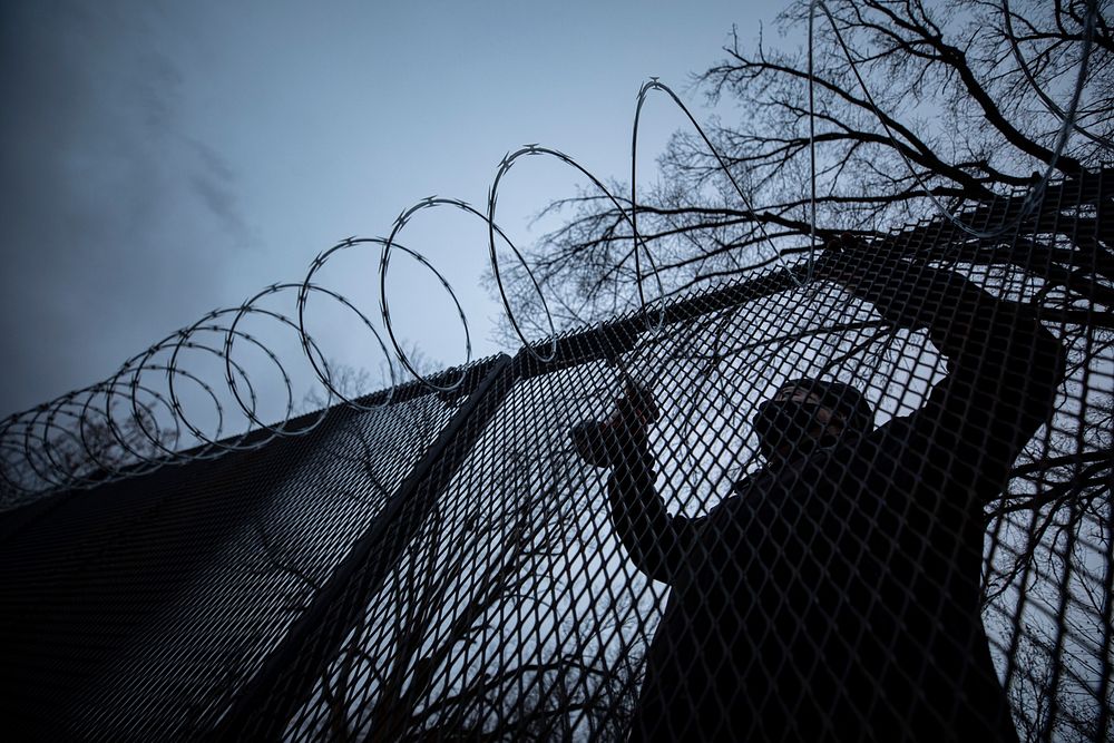 A municipal worker secures c-wire on fencing at a National Guard security post near the Capitol in Washington, D.C., Jan.…