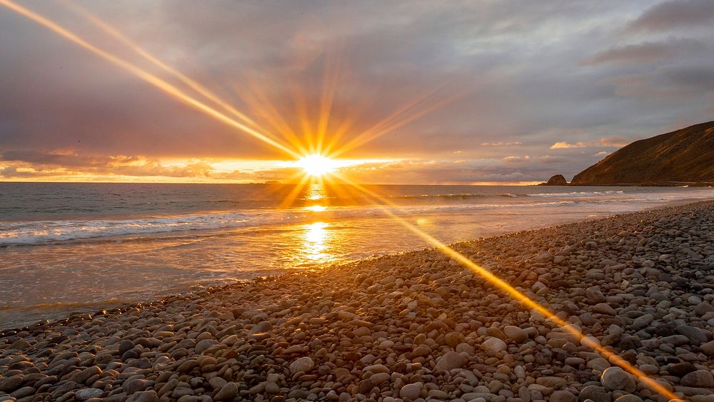 Sun rays on beach, sunset. Original public domain image from Flickr