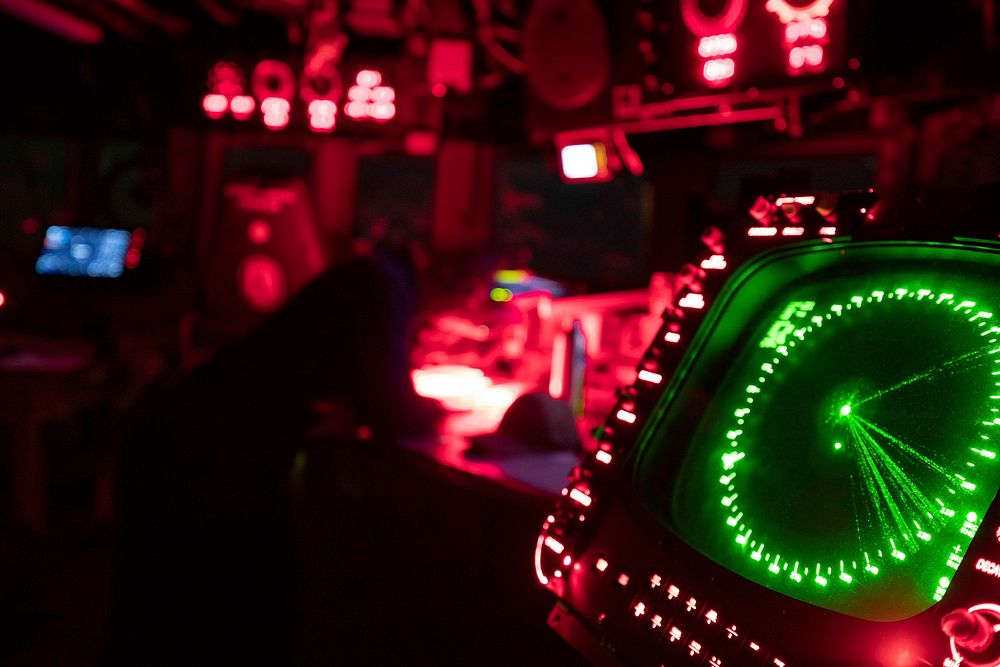 MEDITERRANEAN SEA. Red lights light up the bridge of the Arleigh Burke-class guided-missile destroyer USS Porter (DDG 78) at…