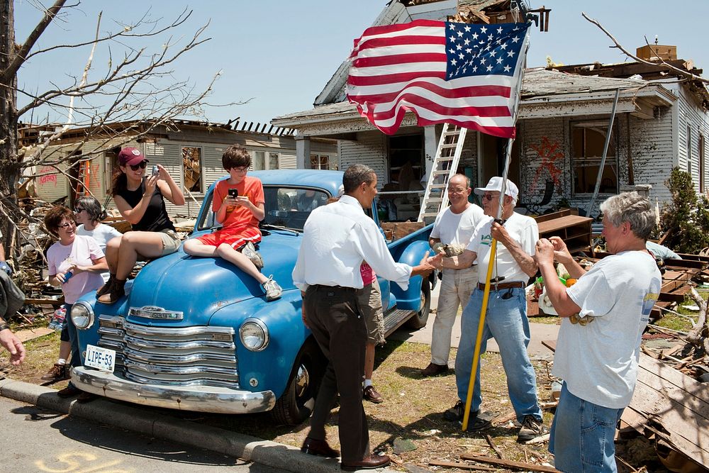 President Barack Obama greets Hugh Hills, 85, in front of his home in Joplin, Mo., May 29, 2011.