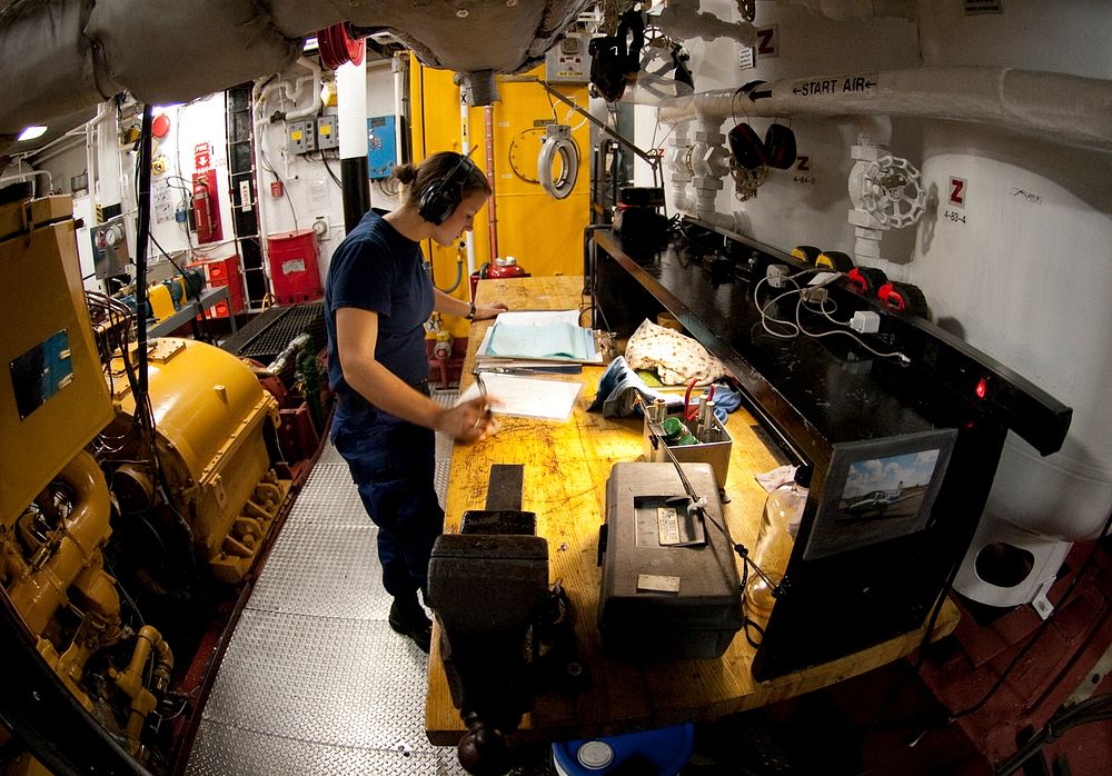 U.S. Coast Guard First Class Cadet Holly Madden reviews her logbook in the engine room aboard the Coast Guard Cutter Eagle…