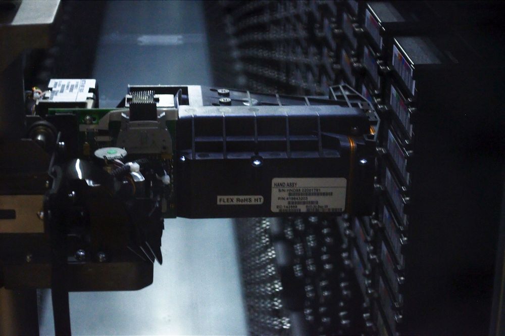 Closeup of robotic arm in StorageTek tape library at NERSC 