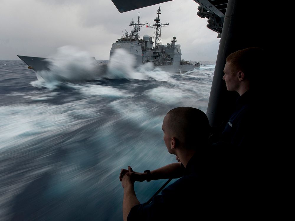U.S. Navy Hull Technician Firemen Douglas Anderson, left, and Patrick Zembol watch as the guided missile cruiser USS Bunker…