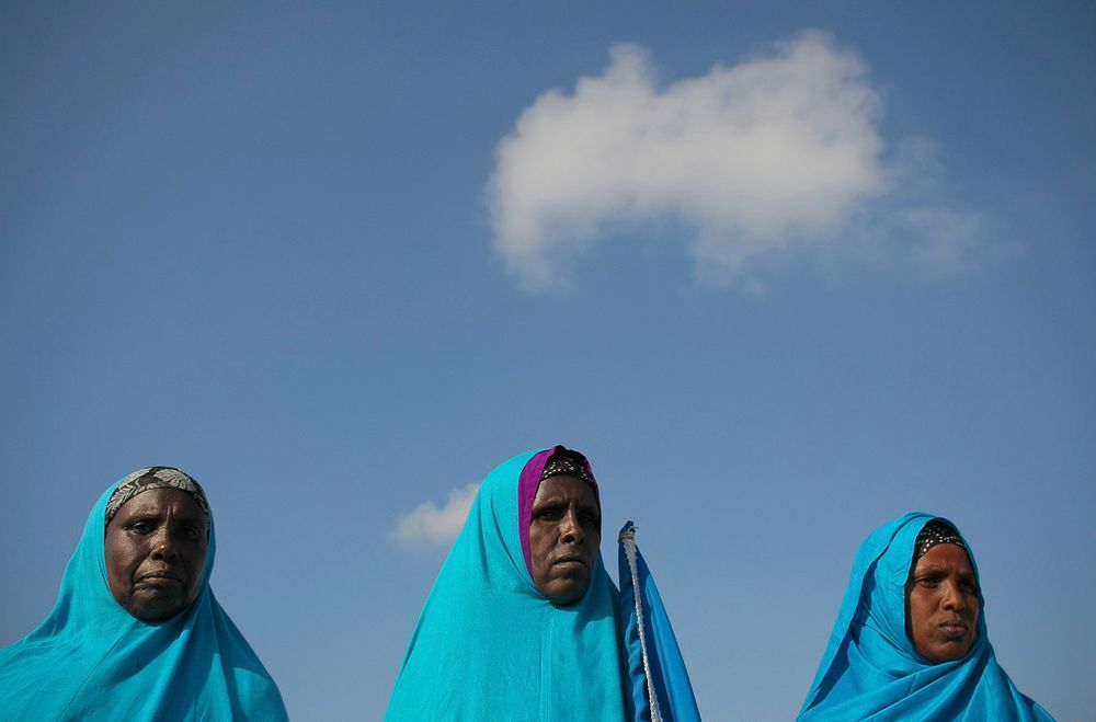 Somali women stand at Mogadishu International Airport 25 March during a ceremony held to recieve the casket containing the…