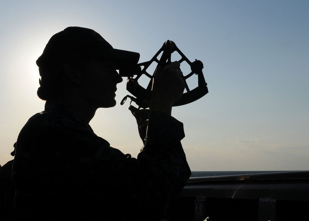 U.S. Navy Ensign Kelly Quirk uses a stadimeter sextant to take a range finding from the port bridge wing of the frigate USS…