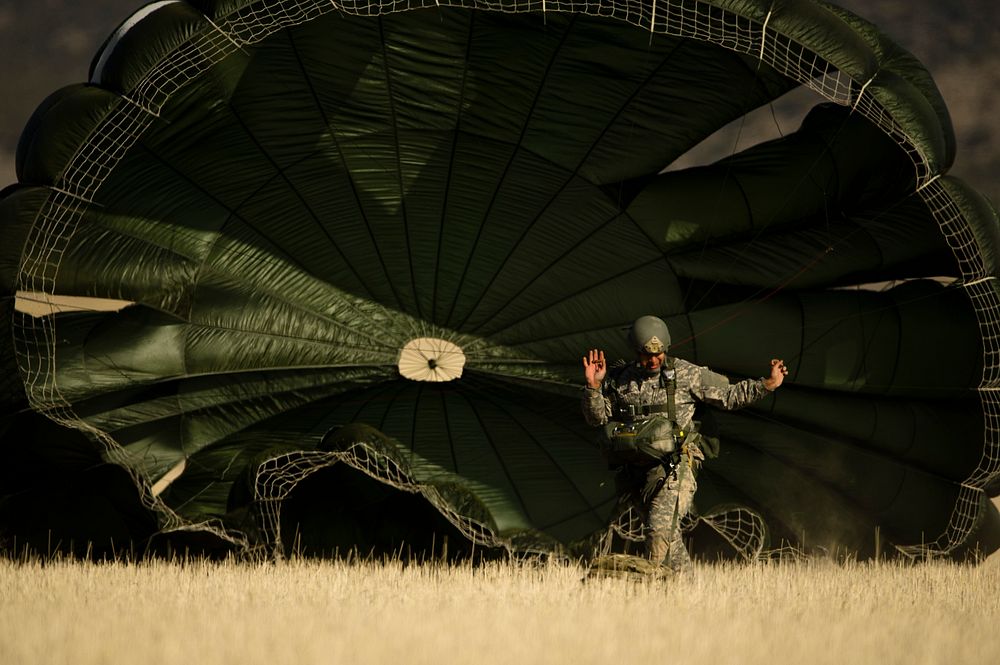 A U.S. Soldier assigned to the 197th Special Troops Company, Utah Army National Guard collapses his parachute after a static…