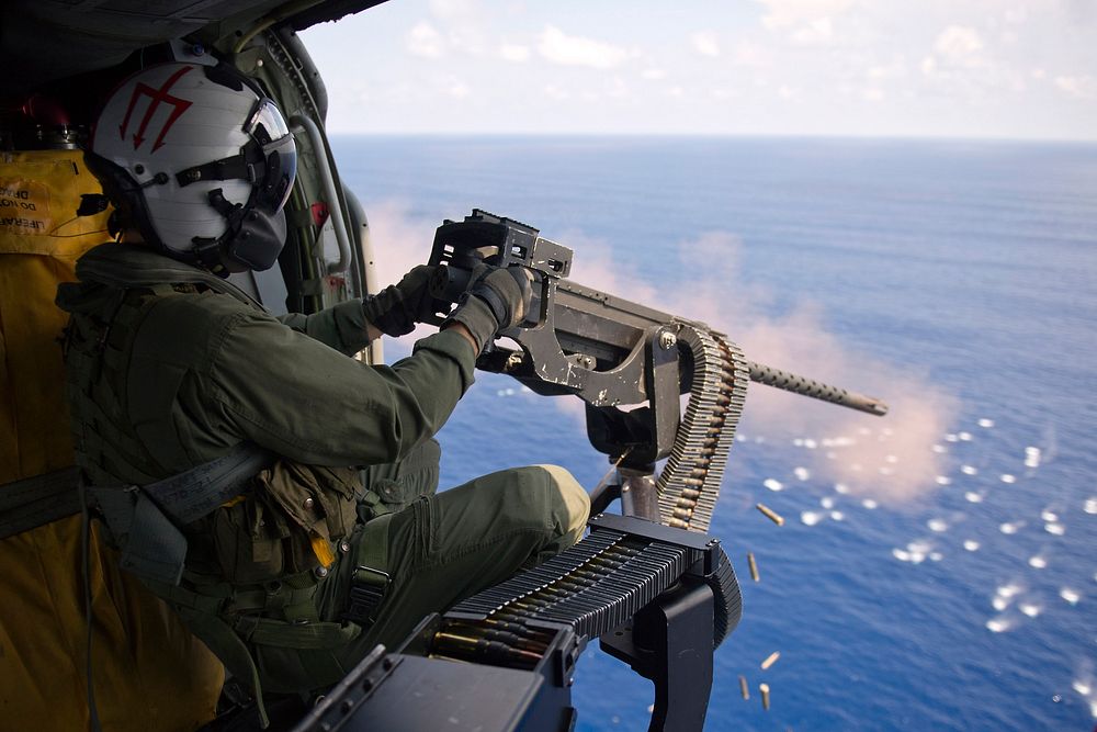 U.S. Navy Aircrewman 3rd Class Bobby Heimovitz, assigned to Helicopter Sea Combat Squadron (HSC) 9, fires a .50-caliber…