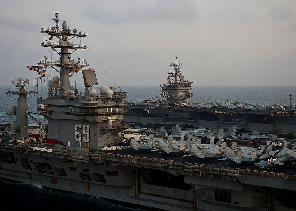 Aircraft carrier USS Enterprise (CVN 65), background, sails alongside aircraft carrier USS Dwight D. Eisenhower (CVN 69)…