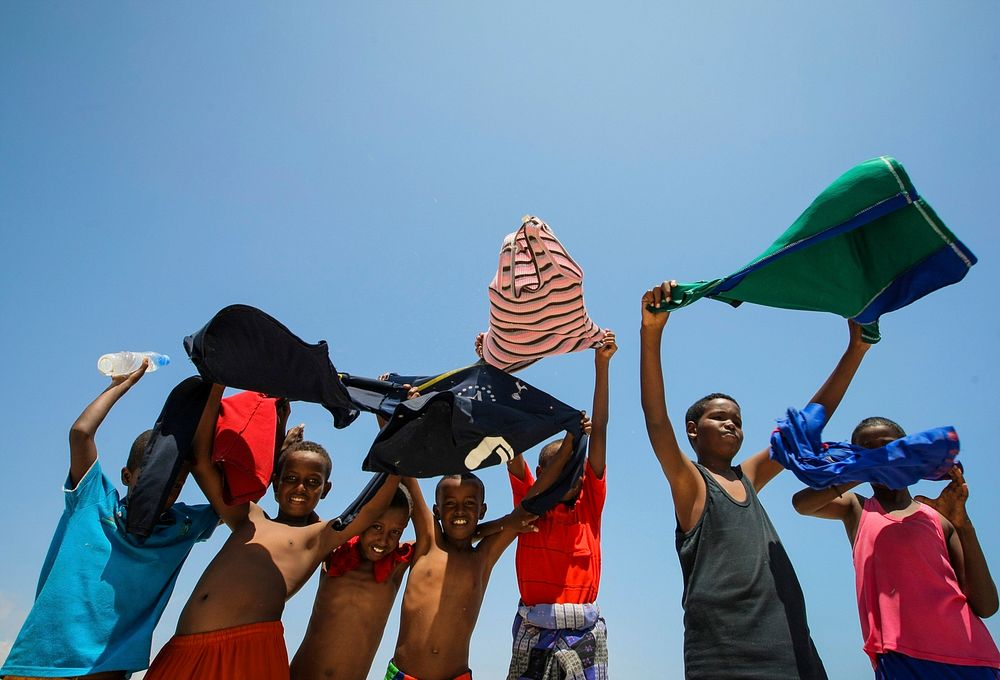 Somali children hold their shirts aloft to dry in the wind at Lido Beach in the Abdul-Aziz district of the Somali capital…