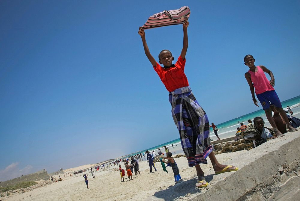 A Somali boy holds a shirt aloft to dry in the wind at Lido Beach in the Abdul-Aziz district of the Somali capital Mogadishu…