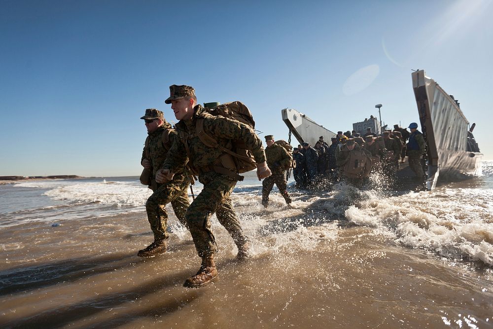 U.S. Marines and Sailors with the 26th Marine Expeditionary Unit step off a landing craft, utility during Hurricane Sandy…