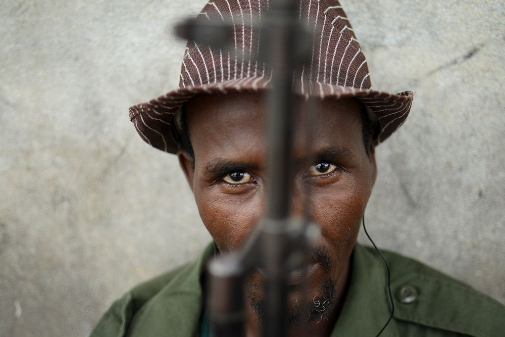 A member of Ras Kambani, a local militia allied with the Kenya Defense Forces in Kismayo city, sits guard over a meeting at…