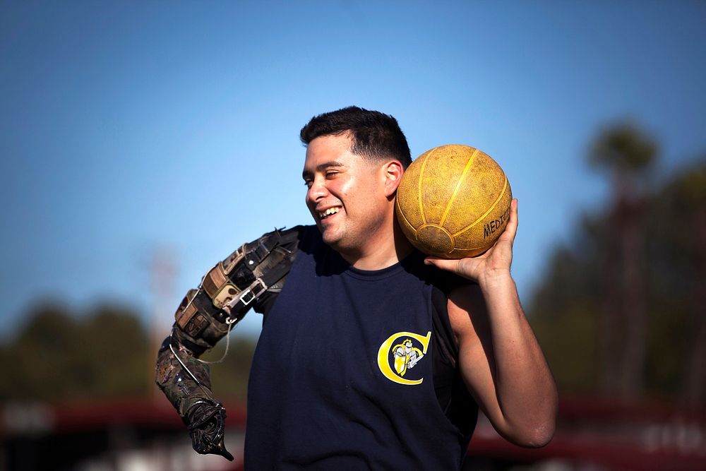 Marine veteran Cpl. Sebastion Gallegos, a San Antonio native, warms up for the shot put with a medicine ball during practice…