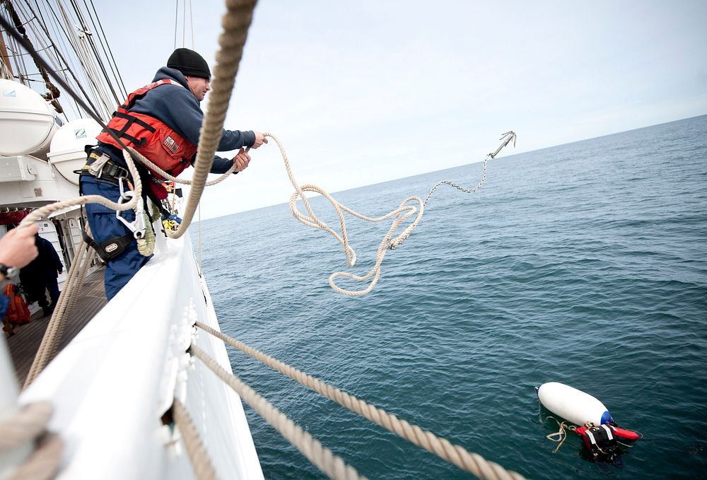 ATLANTIC OCEAN -- Coast Guard Cutter Eagle crew member Fireman Jesse Brown retrieves a "person in the water" during a man…