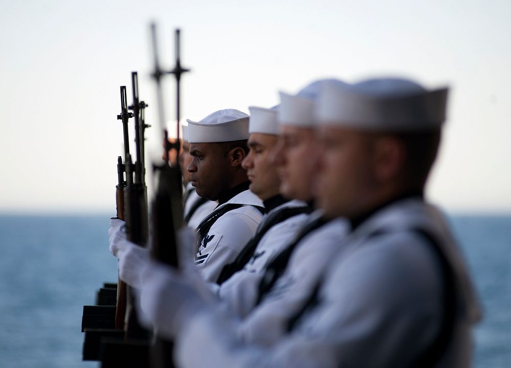 U.S. Sailors with the rifle detail aboard the aircraft carrier USS Carl Vinson (CVN 70) stand at attention during a burial…