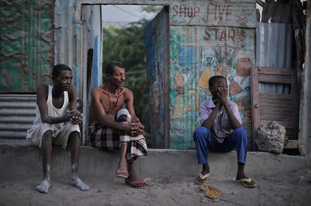 A father and his two sons sit on their doorstep in Mogadishu, Somalia, watching a security operation being conducted on…