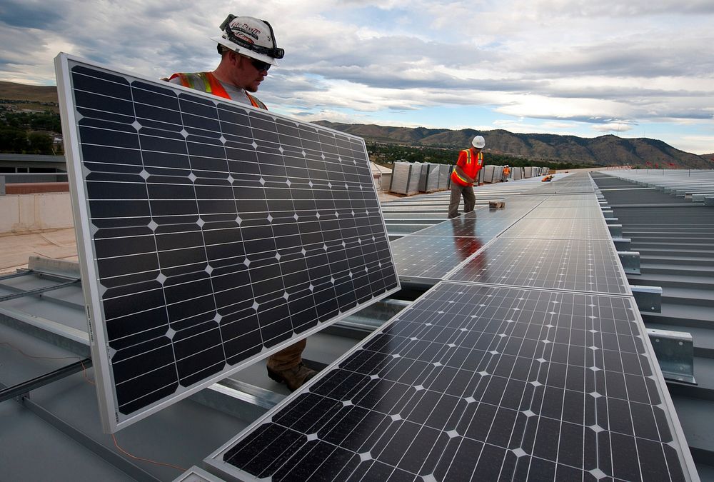 Installing photovoltaic panels on the roof at the Research Support Facility (RSF). NREL works on panels that DOE is using…