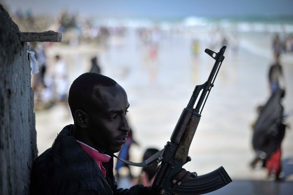 An armed guard stands watch on Lido beach in Mogadishu, Somalia, during Eid celebrations on August 8. Somalia today enjoyed…
