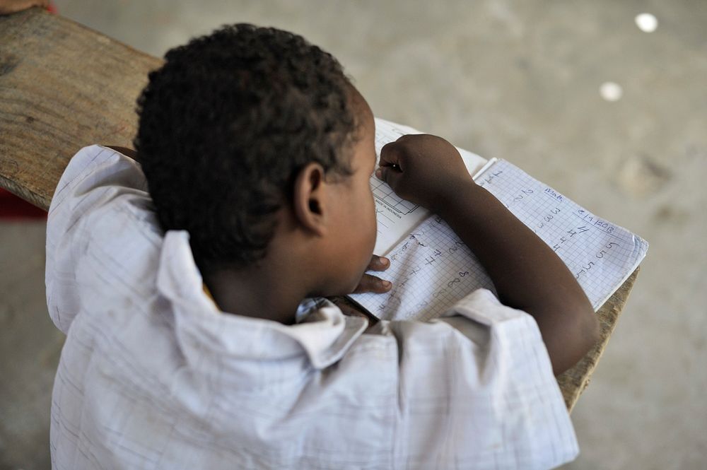 A young boy writes in his excercise book during class at as school run by the Abdi Hawa Center in the Afgoye corridor of…