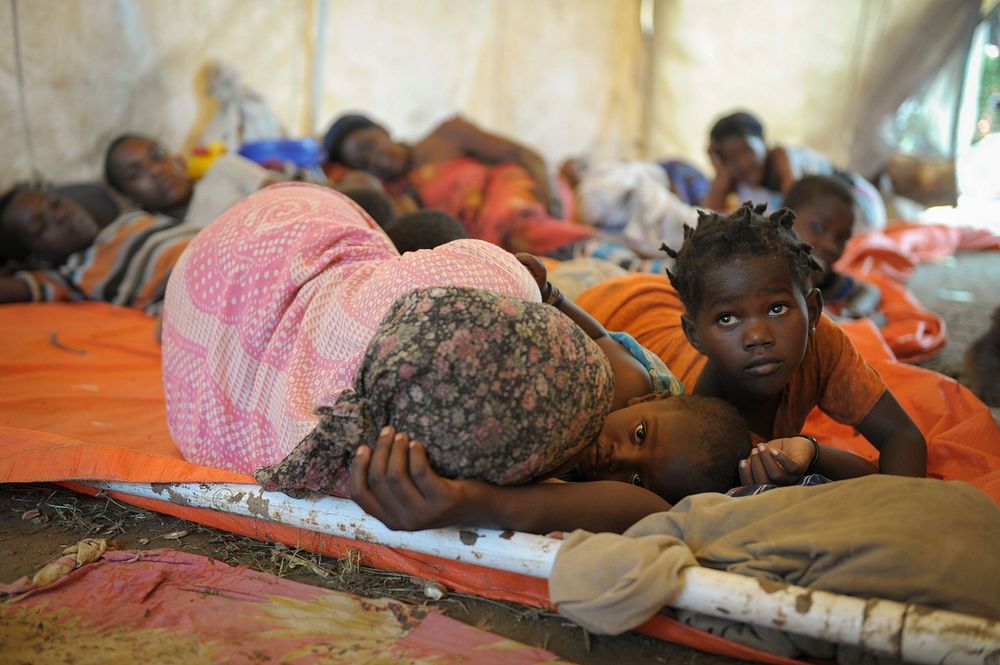 Women and children sleep in a makeshift hospital erected at an AMISOM military camp to help those affected by recent…