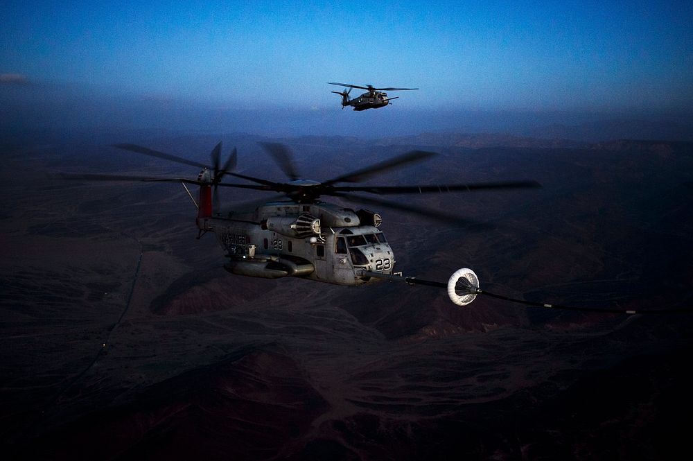 A U.S. Marine Corps CH-53E Super Stallion helicopter receives fuel from an Air Force HC-130J Combat King II aircraft during…