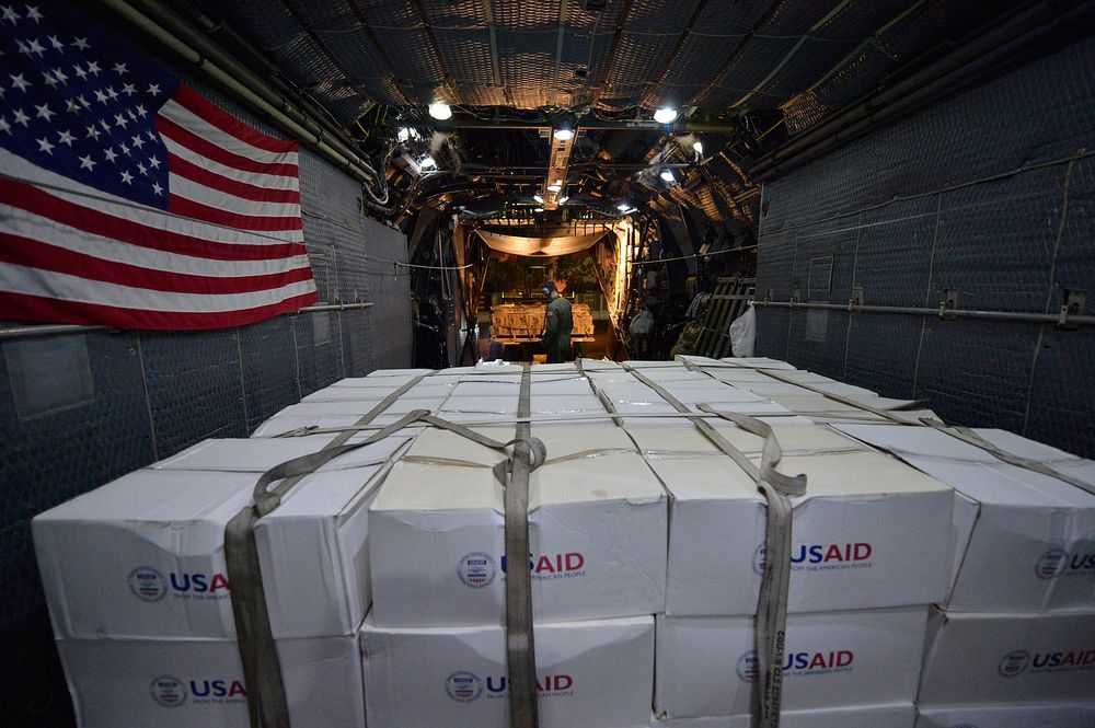 U.S. Airmen assigned to the 1st Special Operation Squadron unload U.S. Agency International Development supplies from an MC…