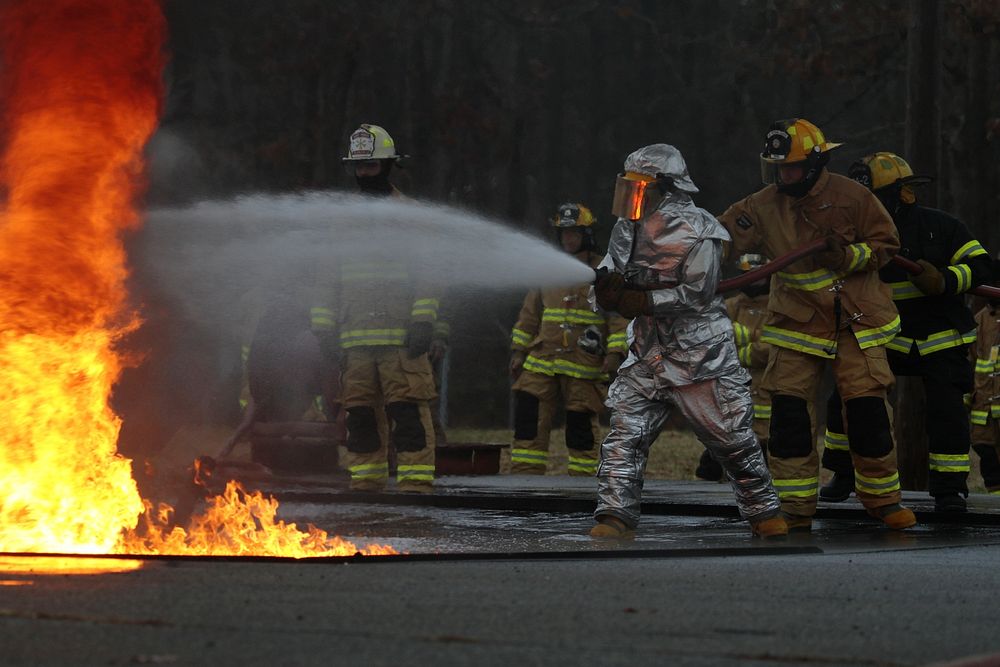 Firefighter extinguishing fire. Original public domain image from Flickr