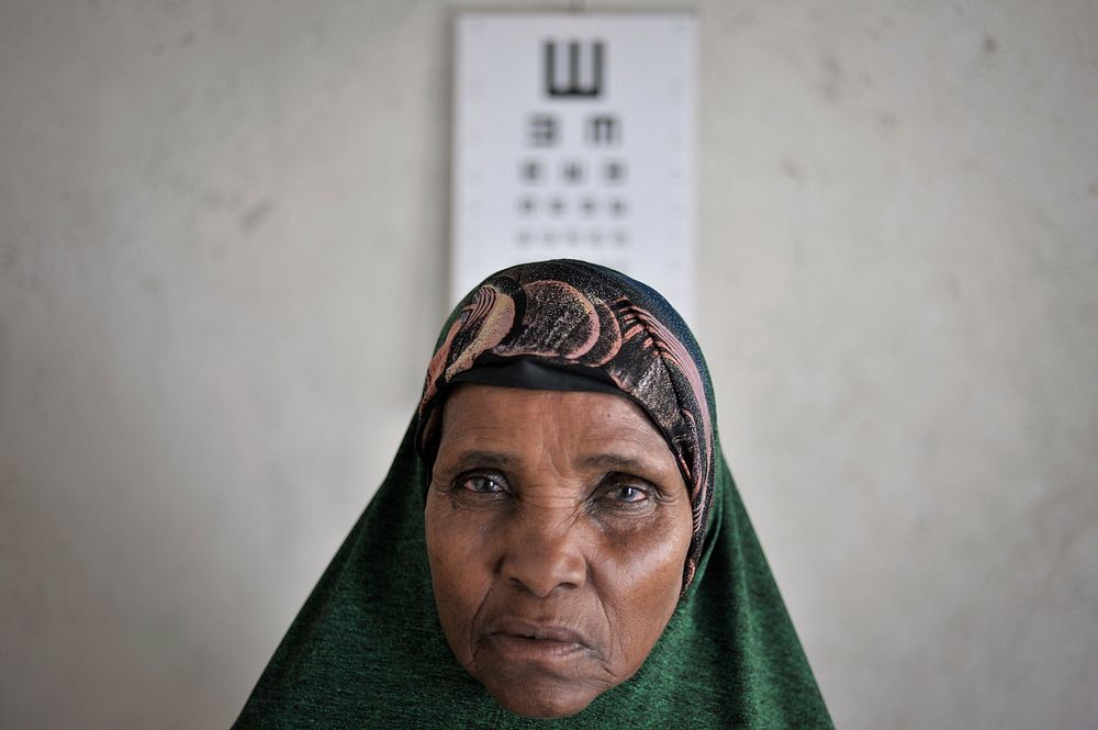 Maryanne Abdi Ali, a 59 year old woman suffering from cataracts, stands in front of an eye chart at an AMISOM medical center…