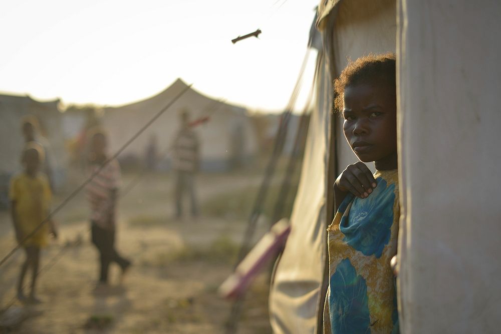 A young Somali girl looks out of a tent at an IDP camp near the town of Jowhar on December 14. Original public domain image…