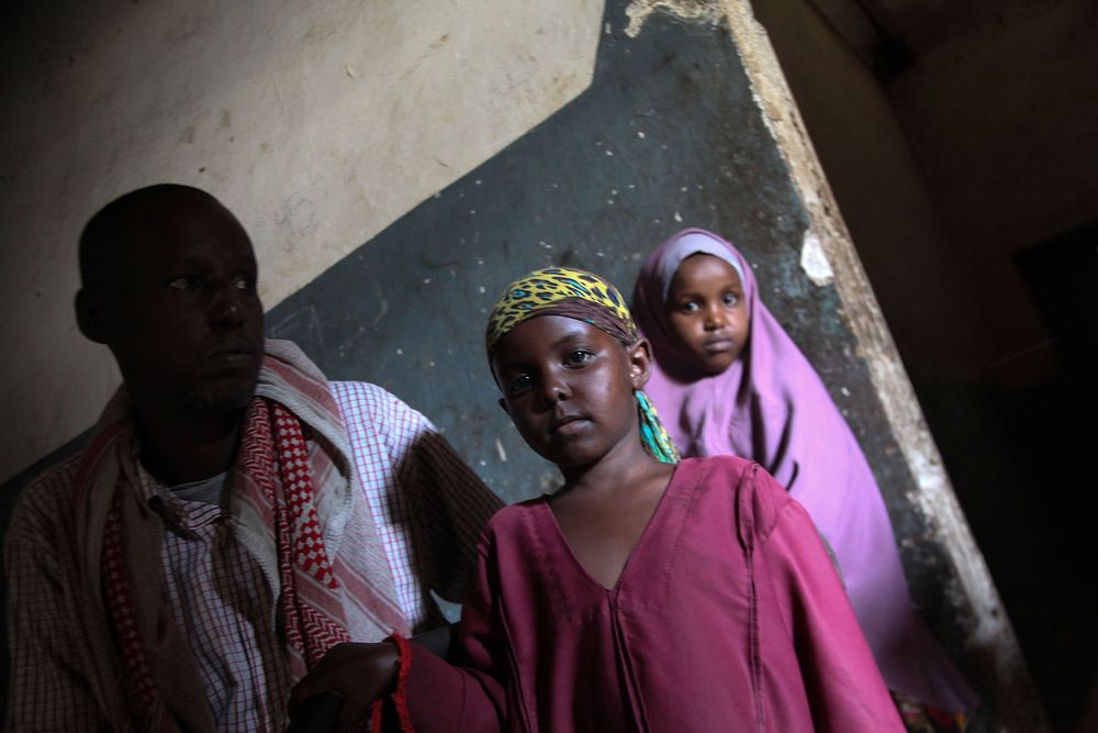 Two young girls sit with a mentally disabled person at Habeb Mental Hospital in the Somali capital of Mogadishu on 24…