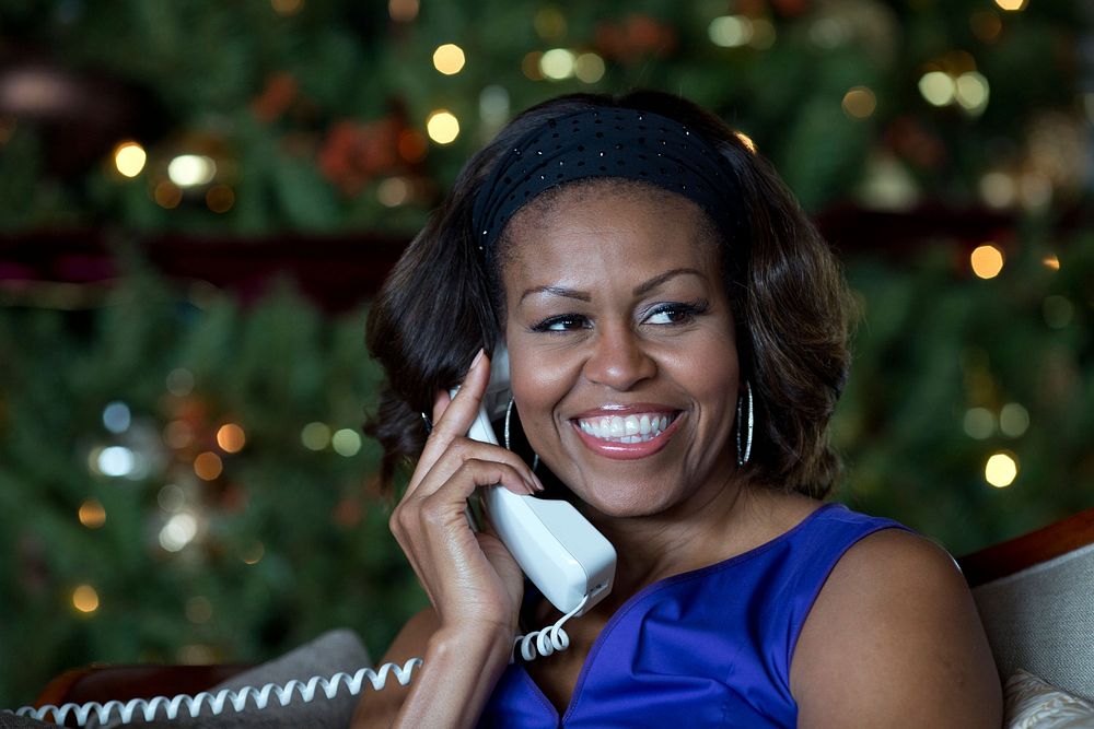 First Lady Michelle Obama reacts while talking on the phone to children across the country as part of the annual NORAD…