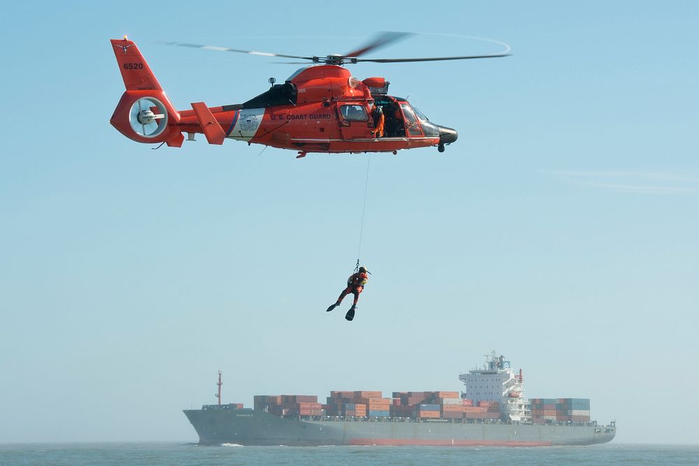 U.S. Coast Guard Petty Officer 3rd Class Andrew Wilson, a rescue swimmer with Air Station Houston, dangles from an HH-65…
