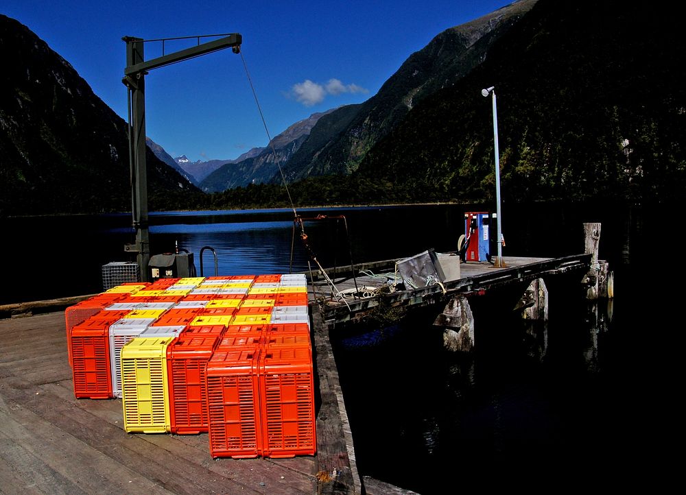 Fish crates. Milford Sound NZColourful plastic fish crates stacked on the jetty in Deepwater Basin. Milford Sound Fiordland…