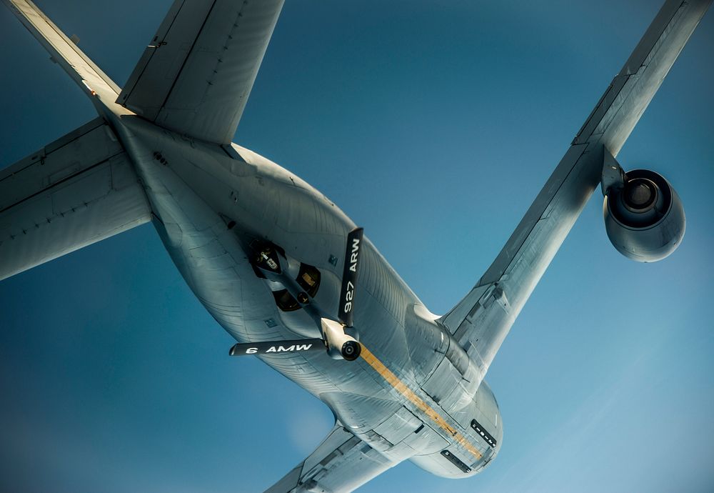 A U.S. Air Force KC-135 Stratotanker aircraft assigned to the 927th Air Refueling Wing flies overhead after refueling a C-17…