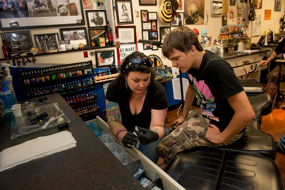 Tattoo artist talking to her customer