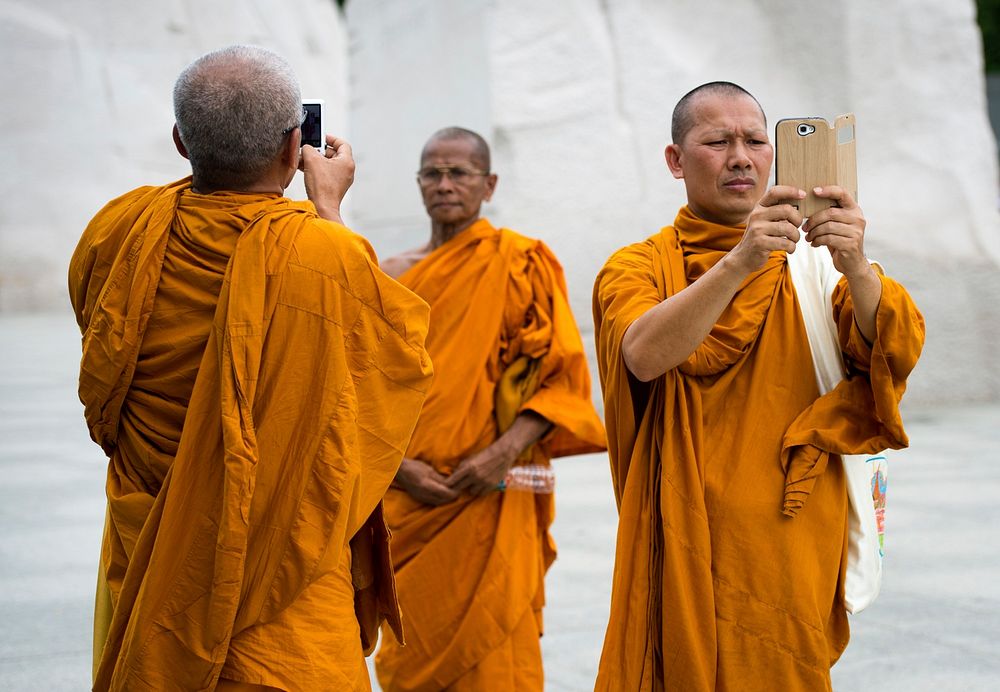 Monks photograph the moment June 19, 2014, at the Martin Luther King Jr. Memorial in Washington, D.C. Traveling from a…