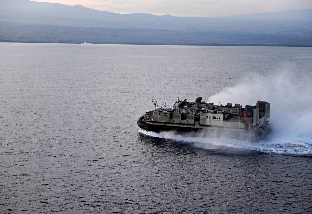 A U.S. Navy landing craft, air cushion attached to Amphibious Craft Unit 5 heads to the harbor from the amphibious assault…