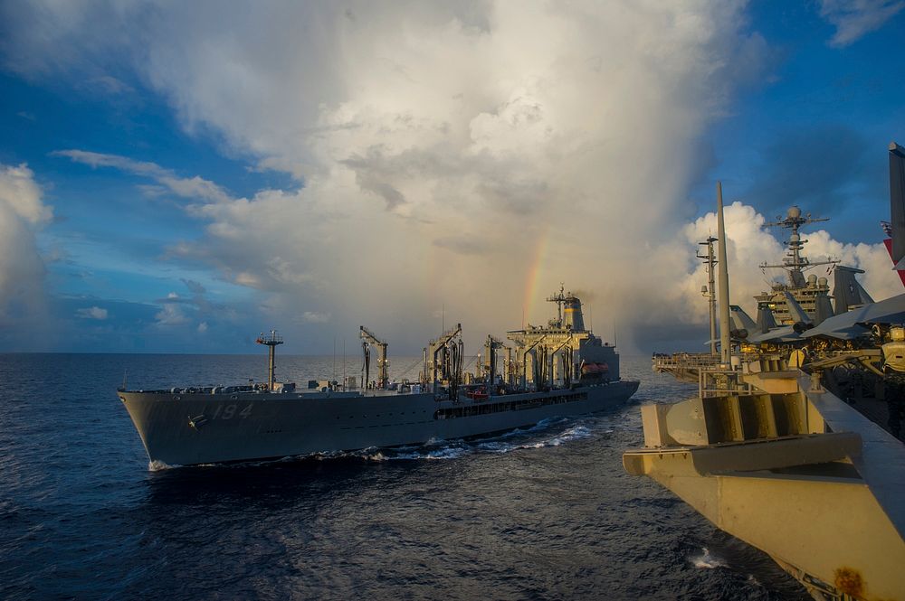 The fleet replenishment oiler USNS John Ericsson (T-AO 194), left, steams alongside the aircraft carrier USS George…