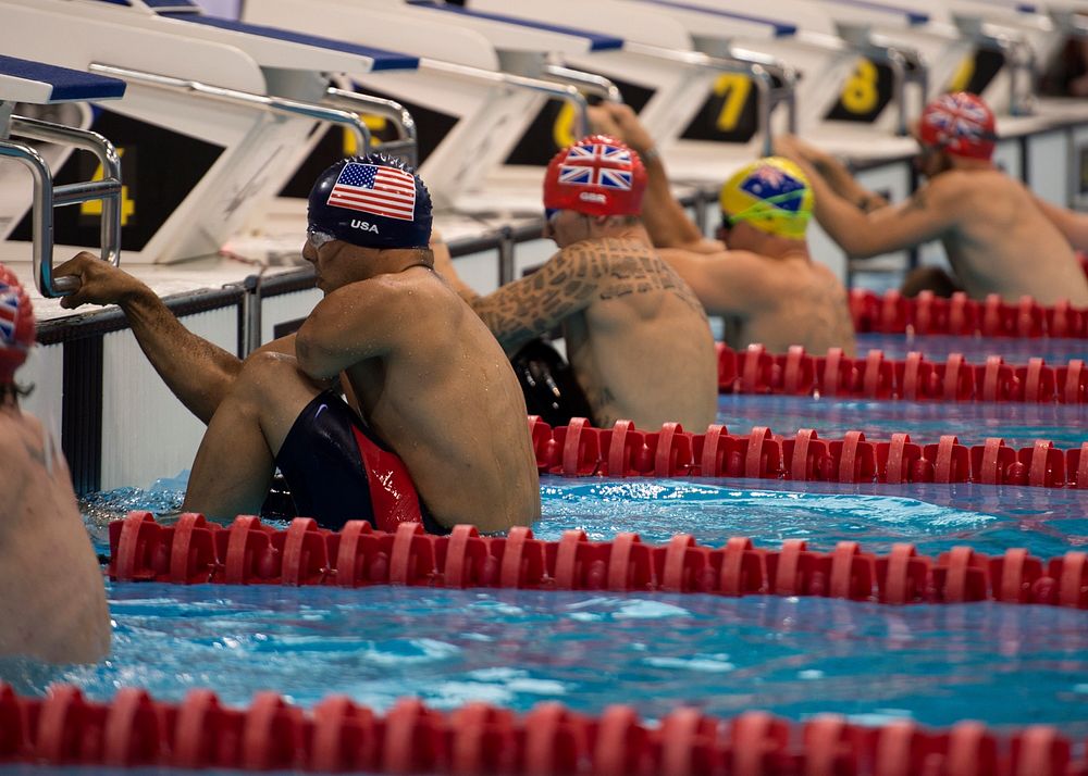 Retired U.S. Army Staff Sgt. Michael Kacer, left, prepares for the 50-meter backstroke race during the swimming portion of…