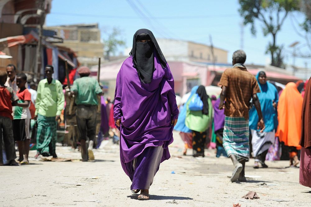 A Somali woman walks down the street in Mogadishu's Hamar Weyne market on October 3. Ahead of Eid al-Adha, which begins this…