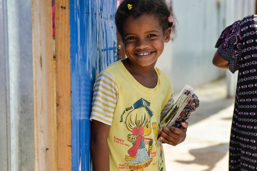 A young girl smiles after receiving a packet of dates from AMISOM's Woman & Child Protection Office, Kaoutar Kaddouri…