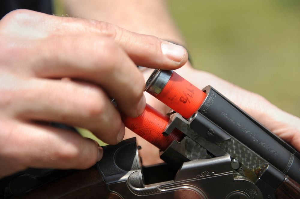 Detailed close-up shot of Army Maj. Dave Guida, a member of the Army Skeet Team, loading his 12-gauge shotgun during the…