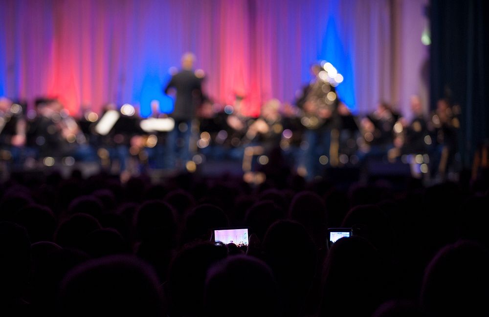 Two audience members video a live performance by the U.S. Army Europe (USARE) Band and Chorus during the 2nd annual German…