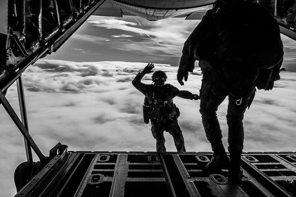 A Portuguese Air Force member waves back to the camera while jumping out of a Canadian C-130 during High Altitude Low…