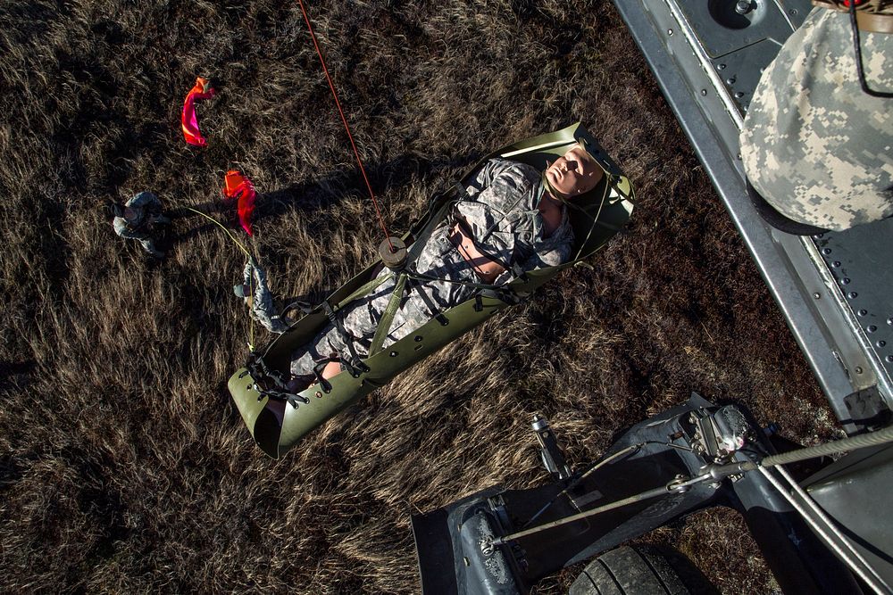 U.S. Army Soldiers assigned to 1st Battalion (Airborne), 501st Infantry Regiment, guide a stretcher as it is hoisted up to a…