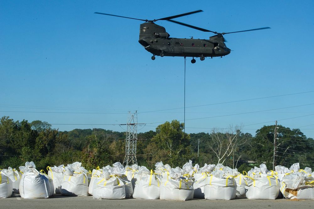 U.S. Soldiers from the 2-238th General Support Aviation Battalion, South Carolina Army National Guard, deliver sandbags with…