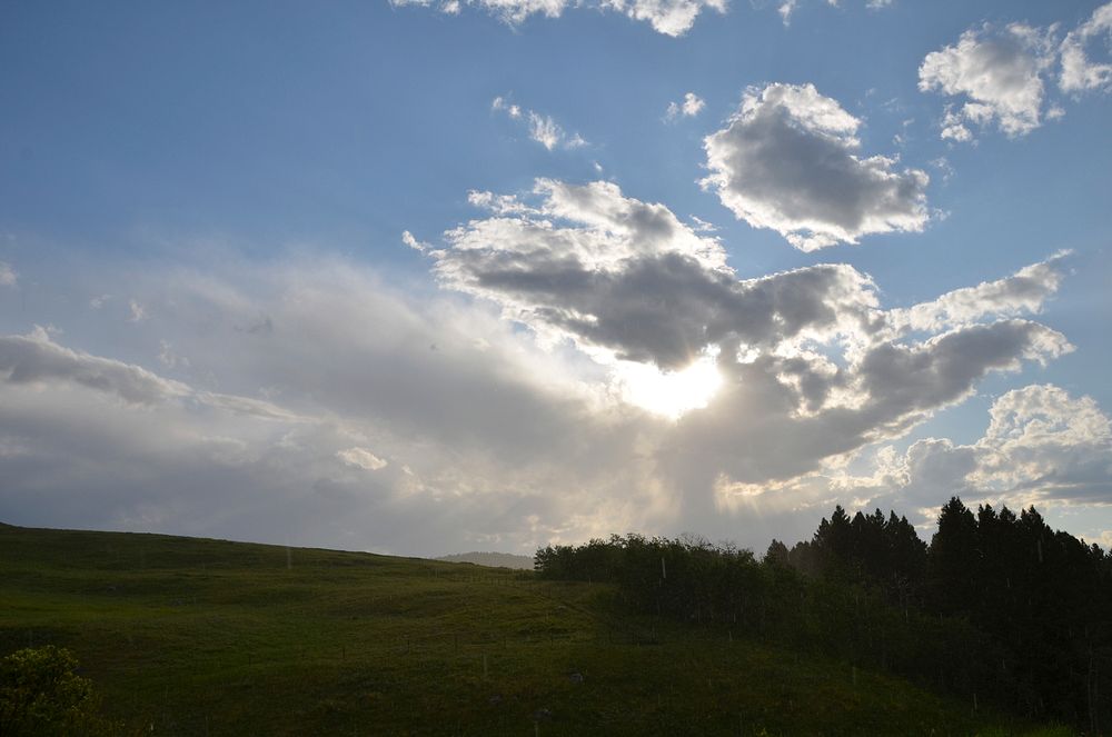 Sun setting behind clouds near Bozeman, Montana. July 2011. Original public domain image from Flickr