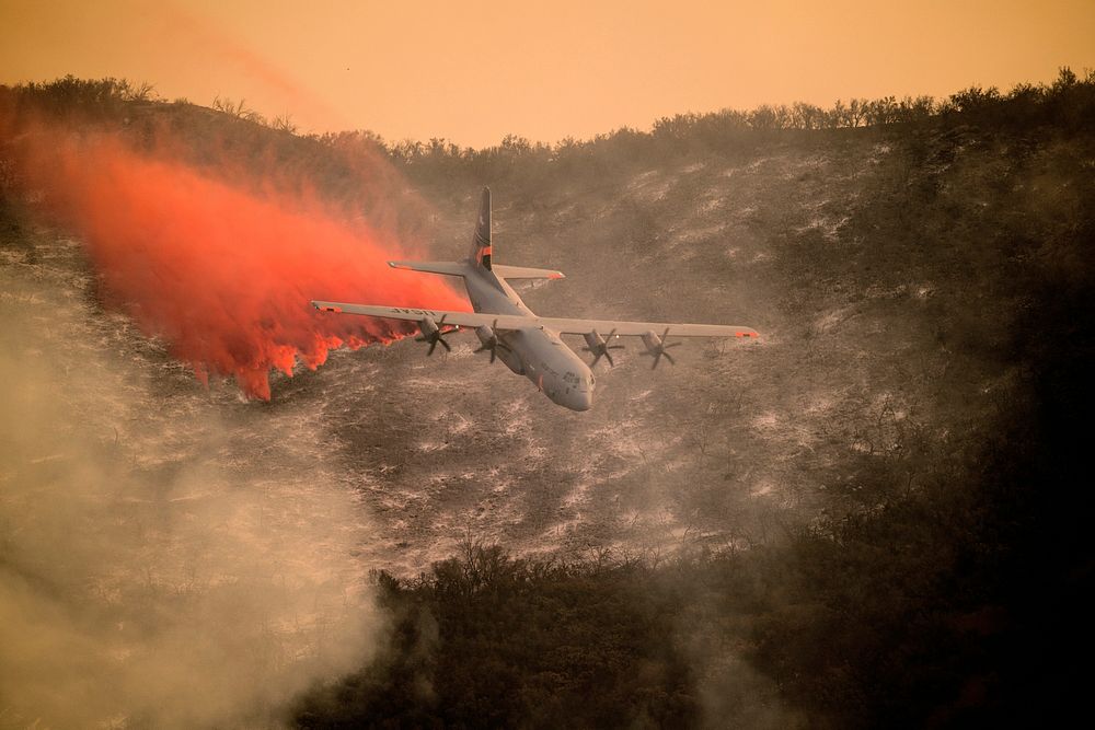 A U.S. Air National Guard C-130J Hercules aircraft equipped with the MAFFS 2 (Modular Airborne Fire Fighting System) drops a…
